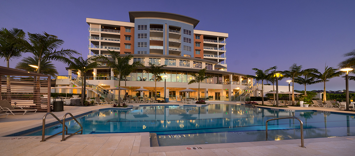 Architectural dusk pool view of Moorings Grand Lake Clubhouse - Naples, FL.