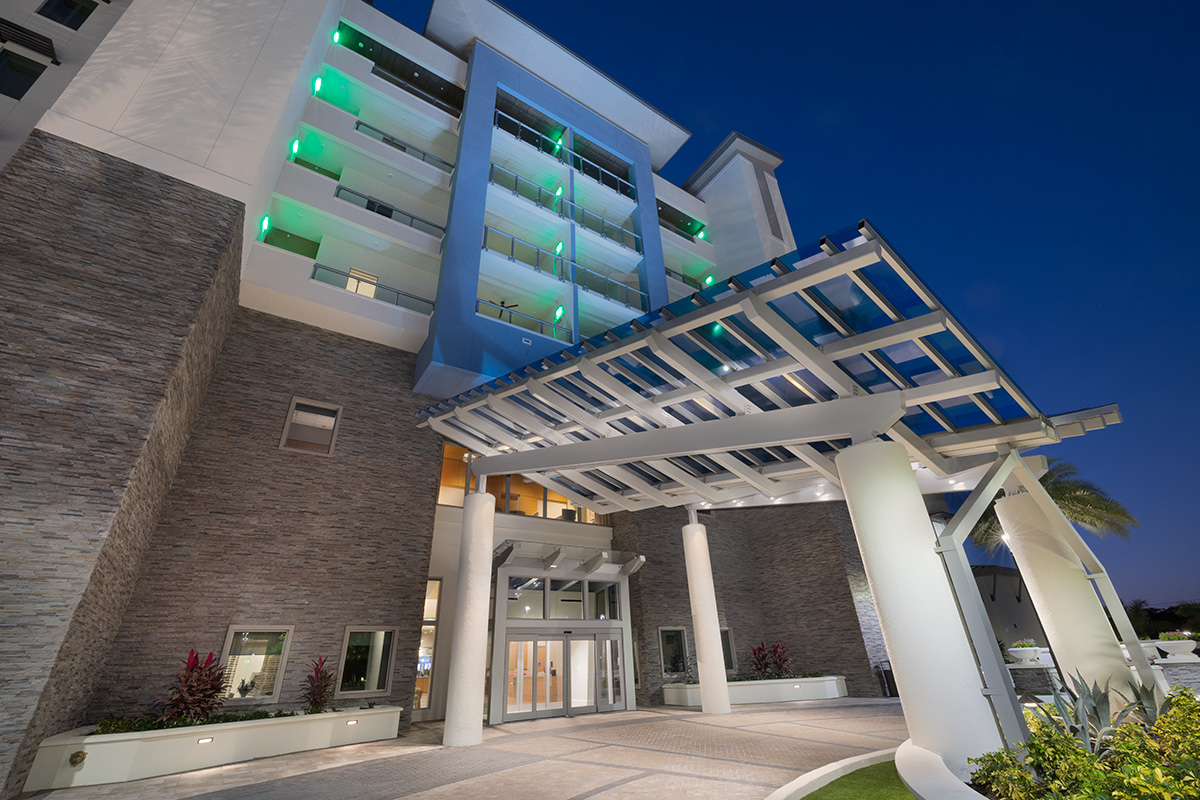 Architectural dusk entrance view of Moorings Grand Lake Clubhouse - Naples, FL.