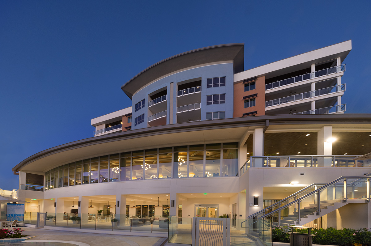 Architectural dusk poolside view of Moorings Grand Lake Clubhouse - Naples, FL.