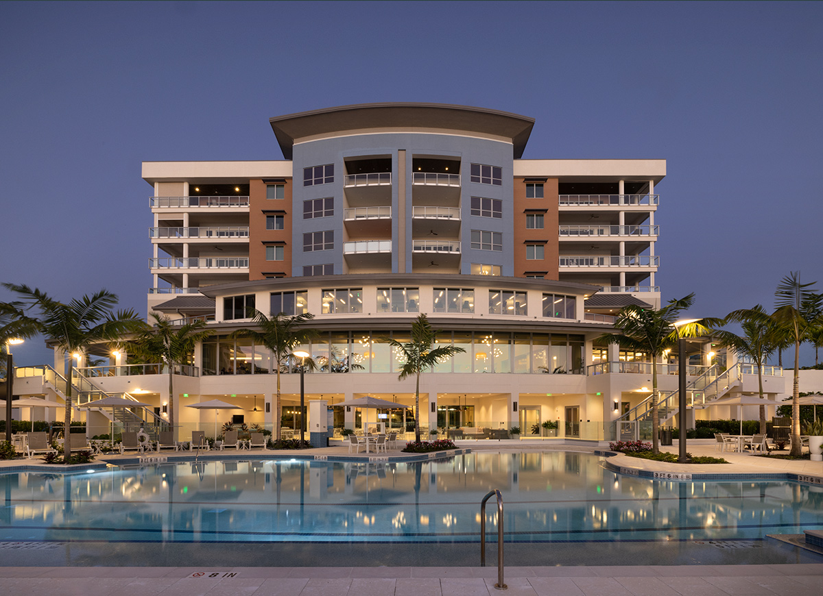 Architectural dusk poolside view of Moorings Grand Lake Clubhouse - Naples, FL.