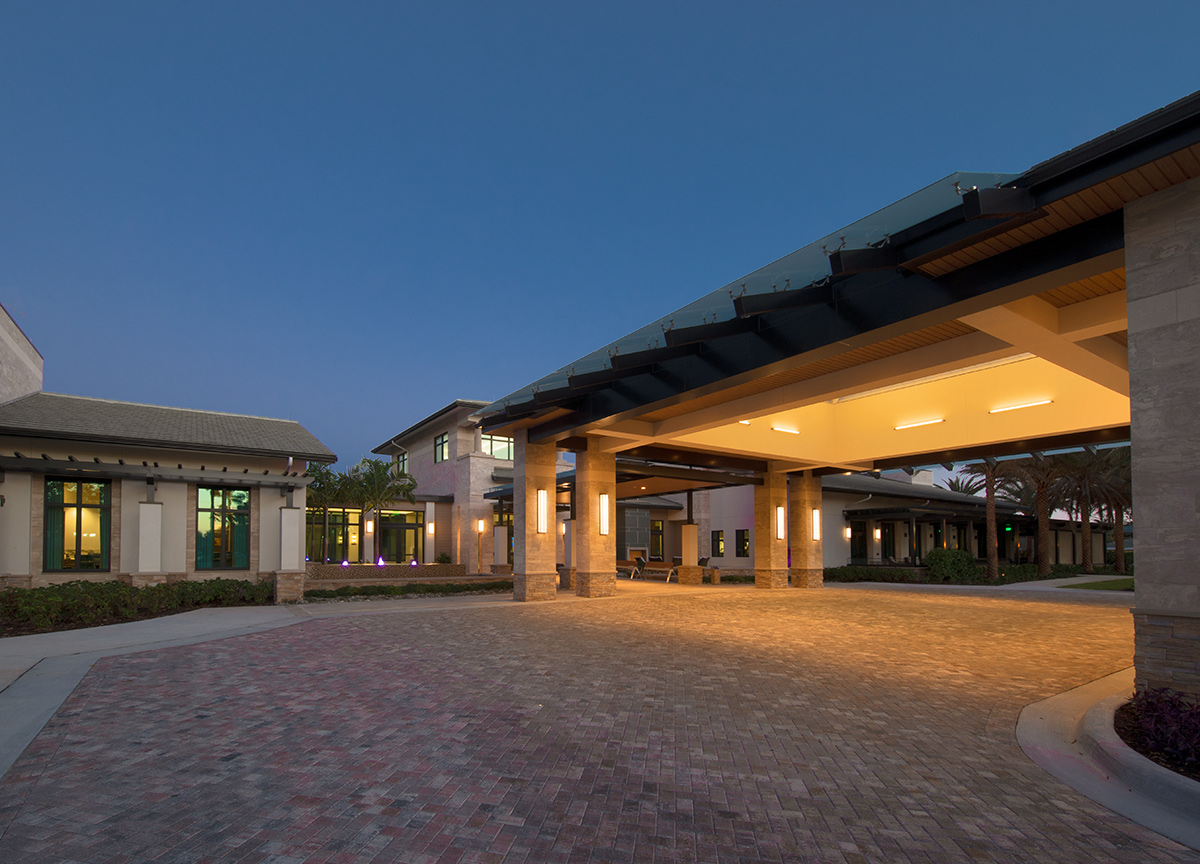 Architectural dusk view of Moorings Park Clubhouse entrance in Naples, FL