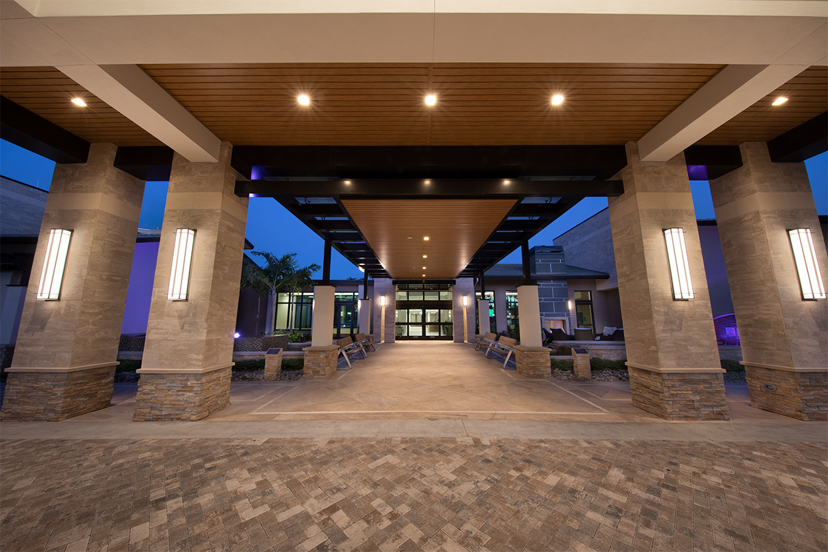 Architectural dusk view of Moorings Park Clubhouse entrance in Naples, FL