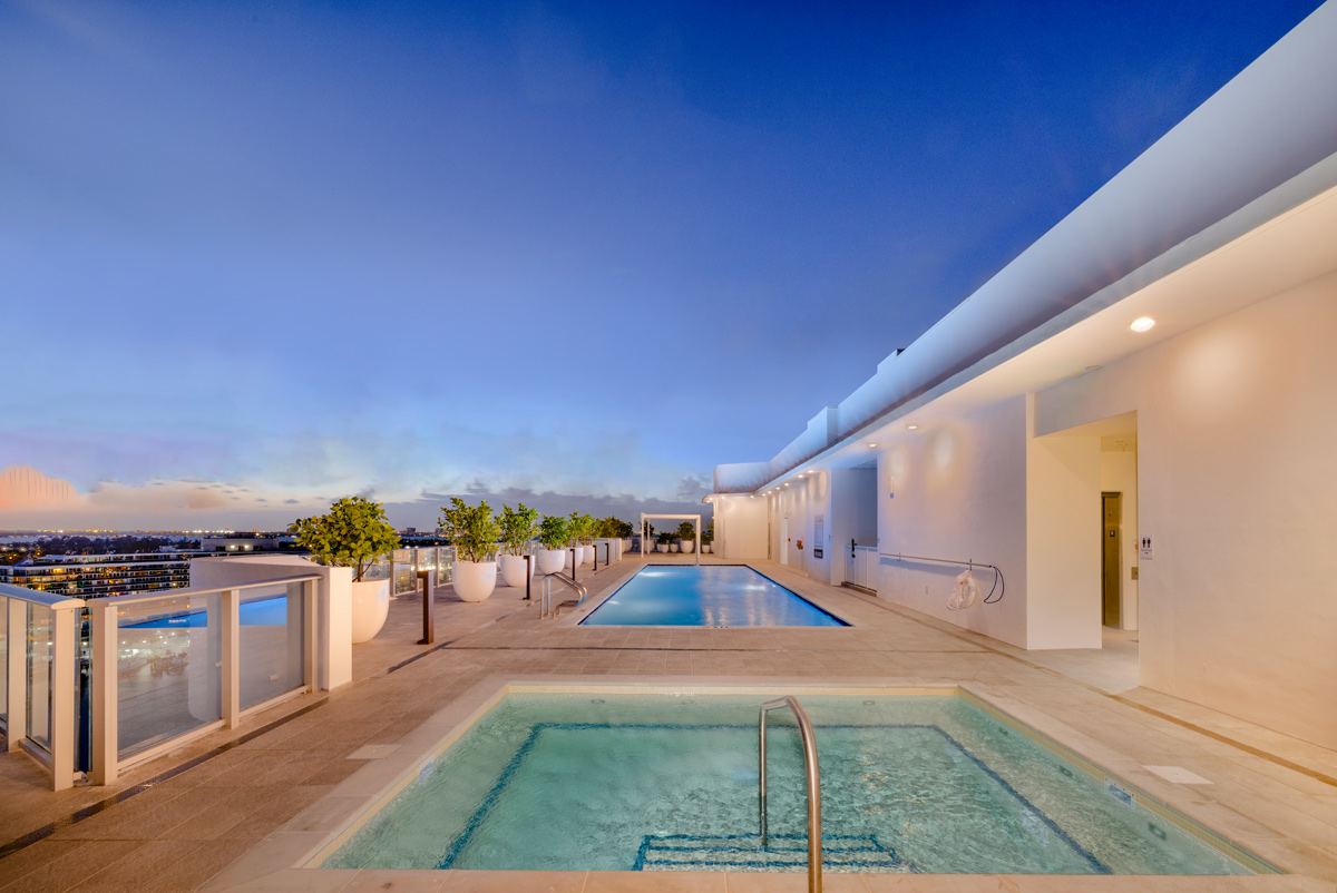 Architectural dusk pool view at Monaco Yacht Club condo in Miami Beach, FL.