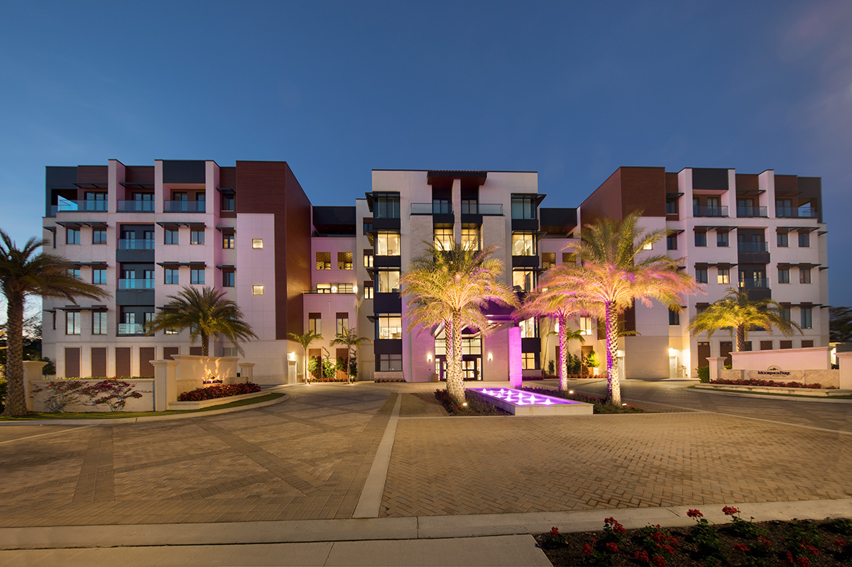 Architectural dusk view of Moorings Park at Grey Oaks senior living in Naples, FL.