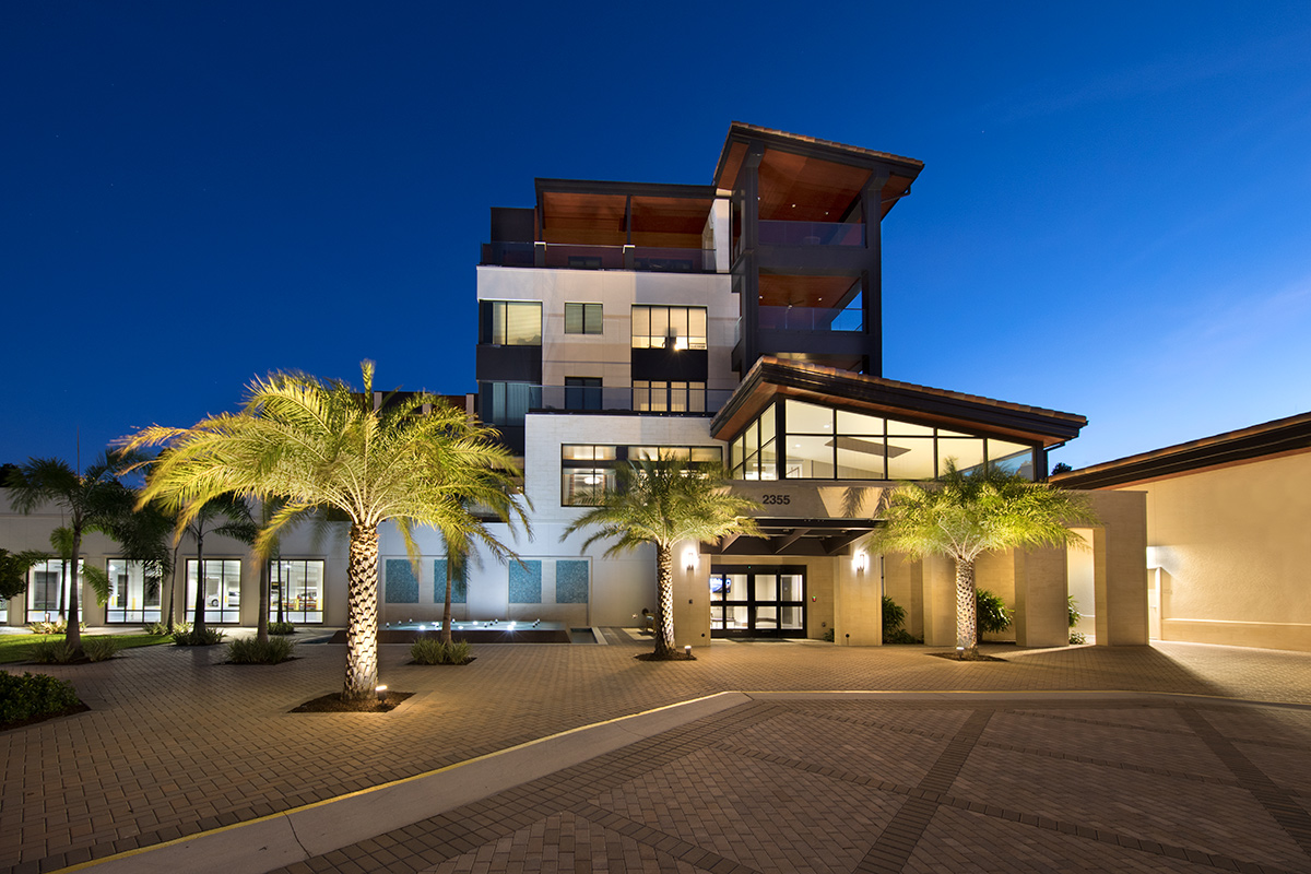 Architectural dusk view of Moorings Park at Grey Oaks senior living in Naples, FL.