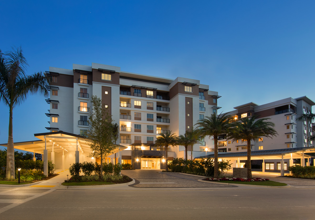 Architectural dusk entrance view of Moorings Park Grande Lake Senior Living in Naples, FL